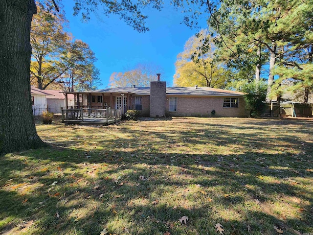 rear view of house with a yard and a deck