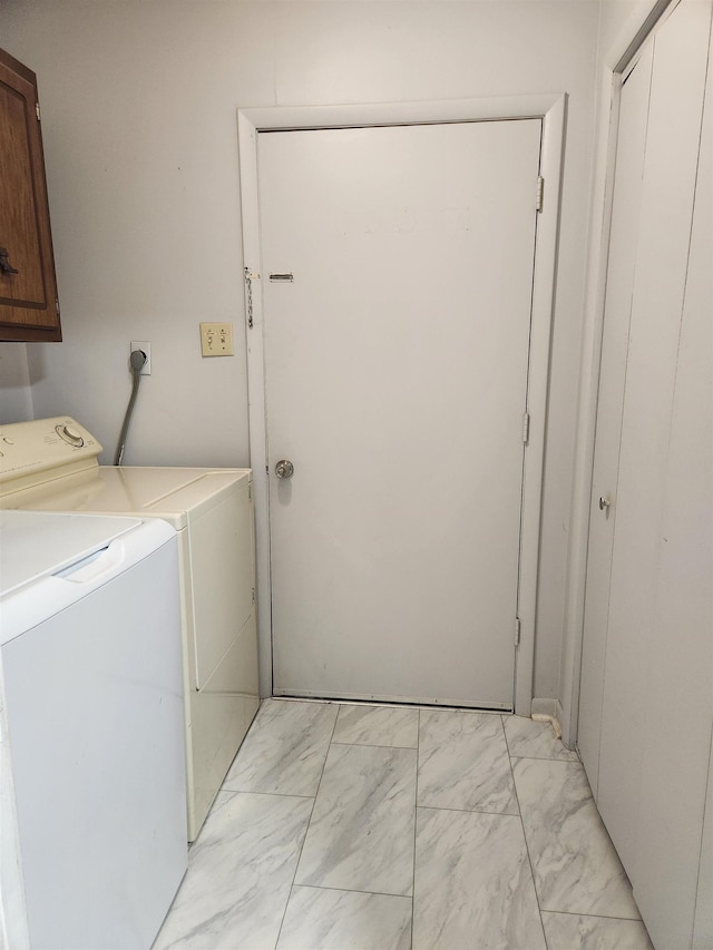 washroom featuring separate washer and dryer and cabinets