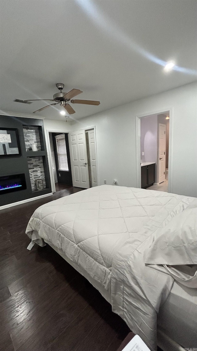 bedroom with ceiling fan, dark wood-type flooring, and ensuite bath