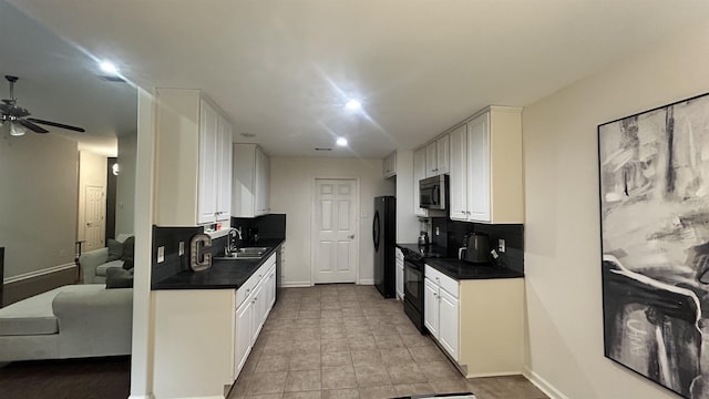 kitchen with decorative backsplash, white cabinets, and black appliances