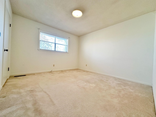 carpeted spare room featuring a textured ceiling