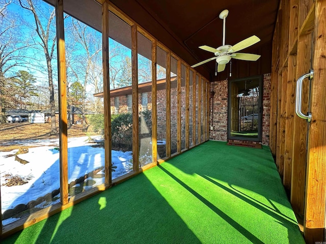 unfurnished sunroom with ceiling fan