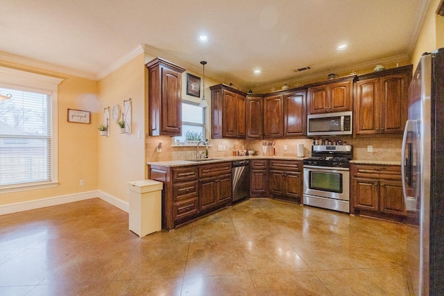 kitchen with tasteful backsplash, sink, crown molding, hanging light fixtures, and stainless steel appliances