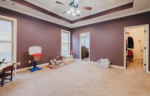 game room with light carpet, ceiling fan, a tray ceiling, and crown molding