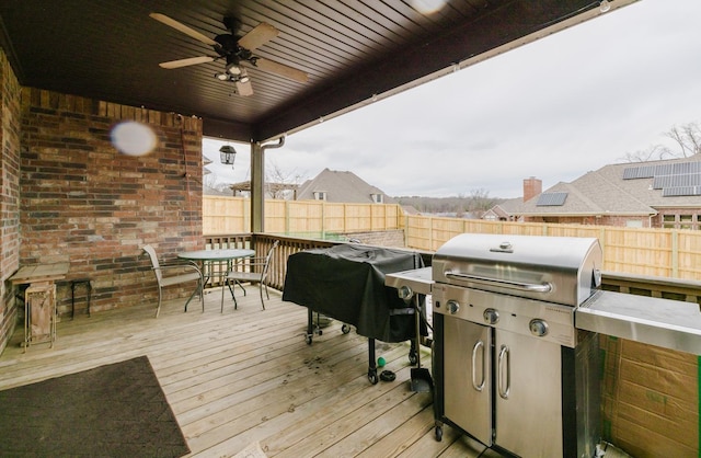 wooden terrace featuring ceiling fan and area for grilling