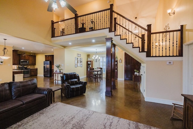 living room with ceiling fan with notable chandelier and a towering ceiling