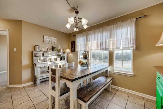 tiled dining room featuring an inviting chandelier