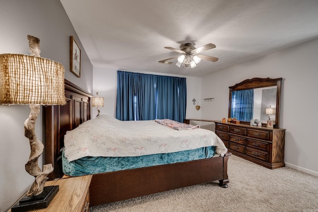 carpeted bedroom featuring ceiling fan and a textured ceiling