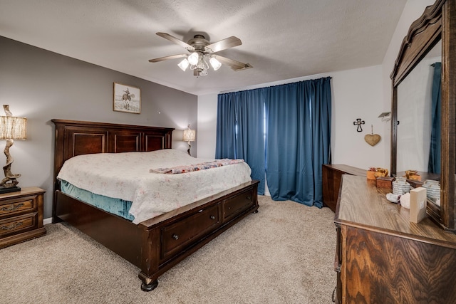 bedroom featuring ceiling fan, a textured ceiling, and light carpet