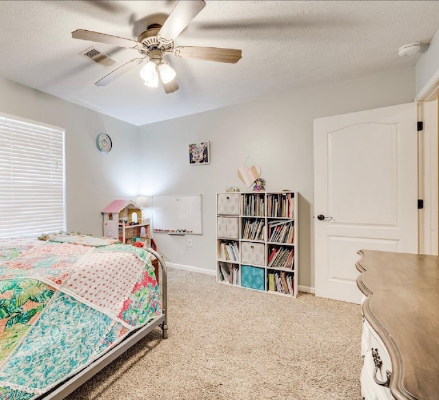 carpeted bedroom with a textured ceiling and ceiling fan