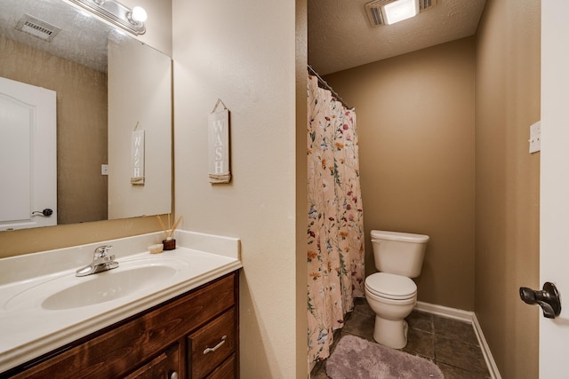 bathroom with a textured ceiling, toilet, vanity, and tile patterned flooring