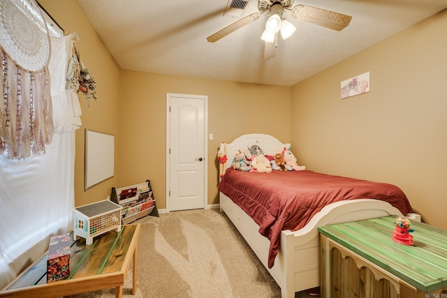 carpeted bedroom featuring ceiling fan and a textured ceiling