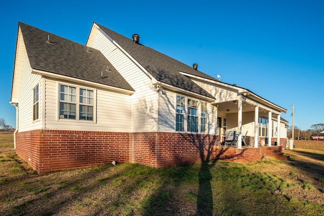 rear view of house featuring a lawn and a patio