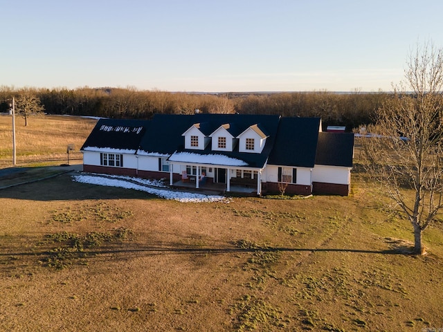 cape cod-style house with a front yard and a rural view