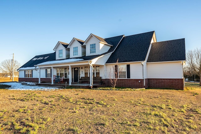 cape cod home featuring a front lawn and a porch