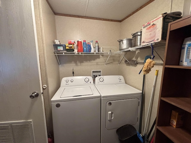 clothes washing area featuring separate washer and dryer, ornamental molding, and a textured ceiling