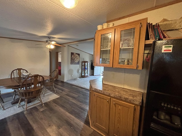 dining area with ceiling fan, dark wood-type flooring, and a textured ceiling