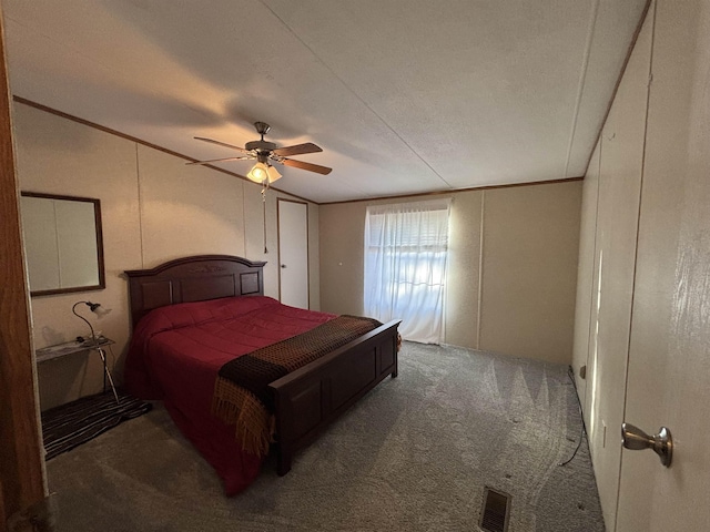 bedroom with ceiling fan, dark carpet, and ornamental molding