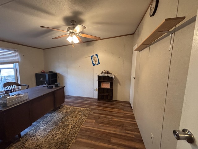 unfurnished office with a textured ceiling, dark wood-type flooring, ornamental molding, and ceiling fan