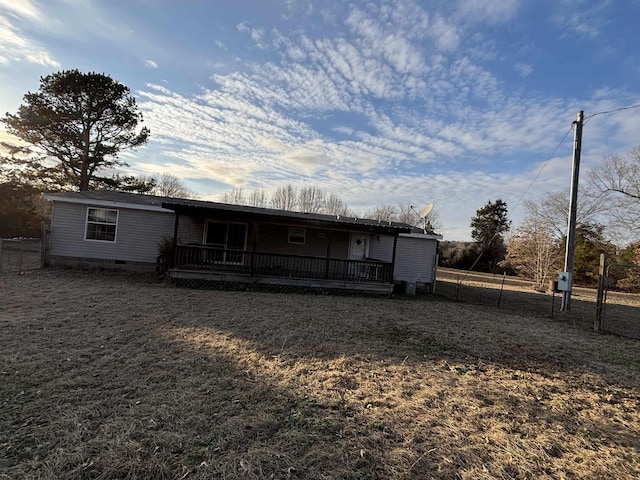 rear view of house featuring a wooden deck and a yard