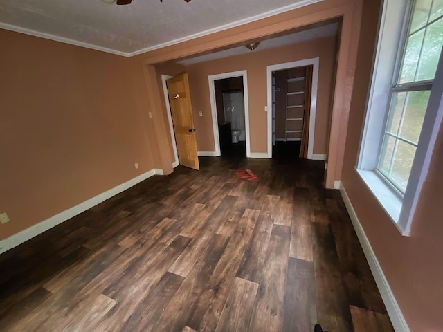 spare room featuring ceiling fan, dark wood-type flooring, and crown molding