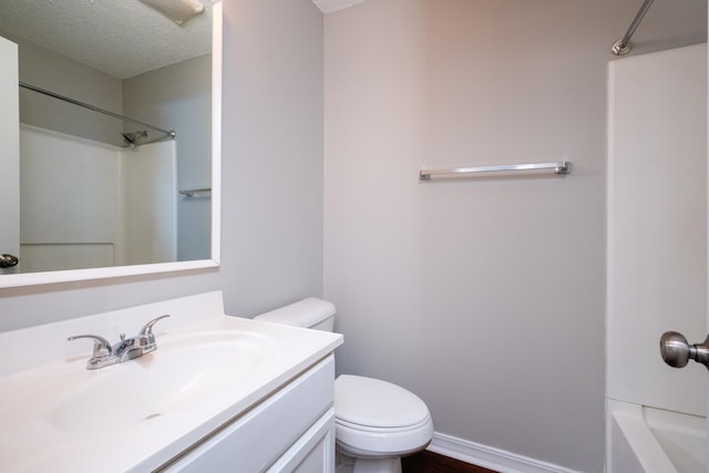 bathroom featuring a textured ceiling, toilet, and vanity