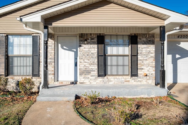 view of exterior entry featuring a porch and a garage