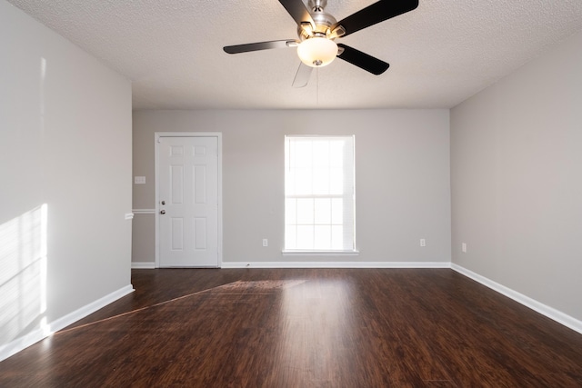 empty room with ceiling fan, a textured ceiling, and dark hardwood / wood-style floors