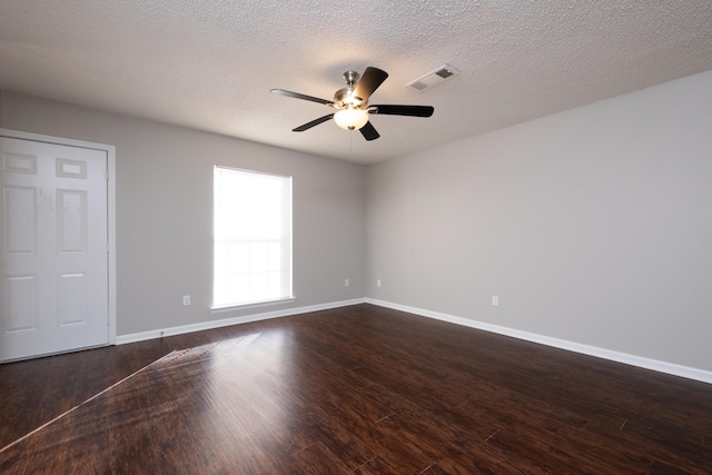 unfurnished room with a textured ceiling, dark wood-type flooring, and ceiling fan