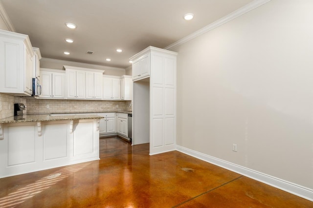 kitchen with a breakfast bar area, decorative backsplash, white cabinets, and light stone counters