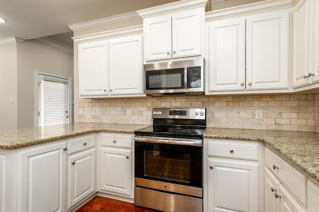 kitchen with kitchen peninsula, stainless steel appliances, light stone countertops, crown molding, and white cabinets