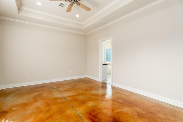 empty room with a raised ceiling, ornamental molding, and concrete flooring