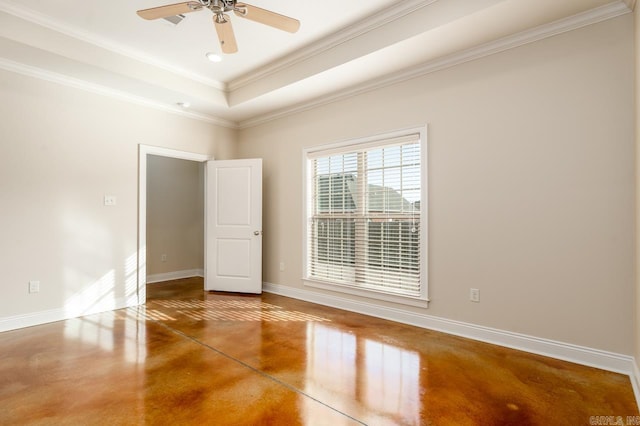 empty room featuring ceiling fan, concrete floors, ornamental molding, and a tray ceiling