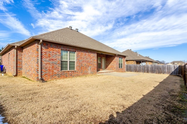 rear view of property with a yard and a patio