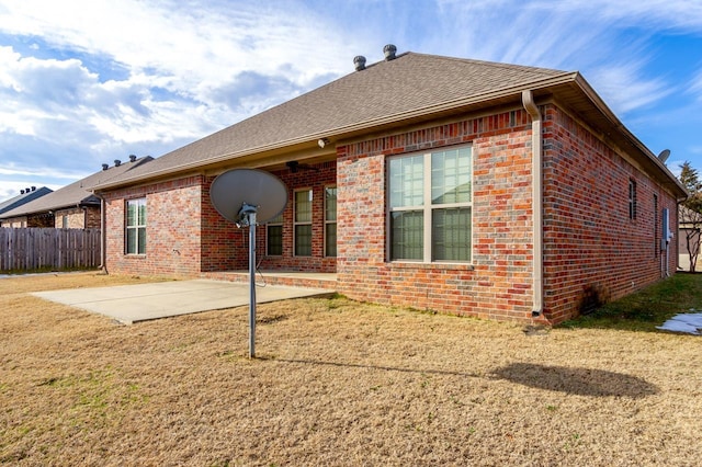 back of house with a yard and a patio