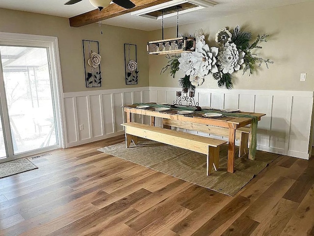 dining room with beam ceiling, ceiling fan, and hardwood / wood-style flooring