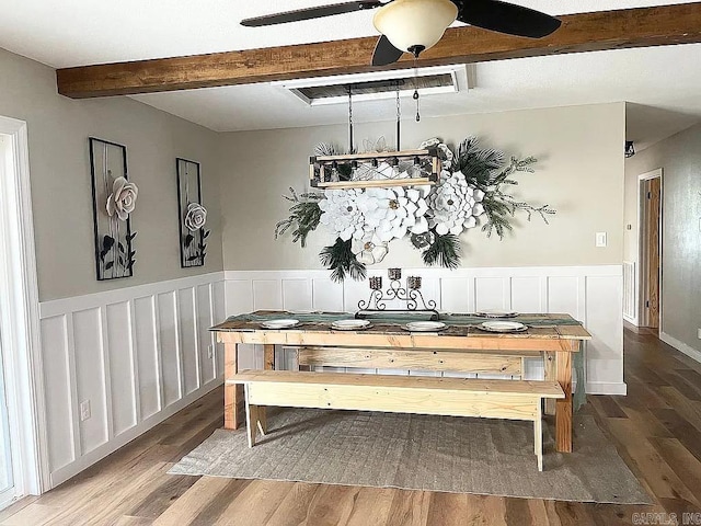 dining space with ceiling fan, hardwood / wood-style floors, and beamed ceiling