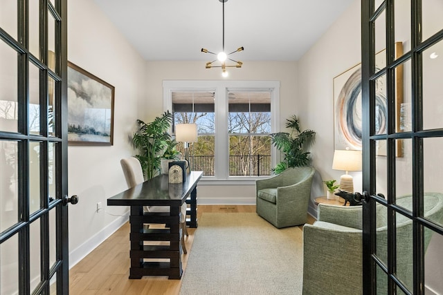 office featuring french doors, a notable chandelier, and hardwood / wood-style flooring