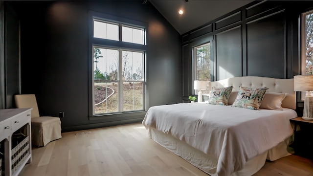 bedroom featuring lofted ceiling and light hardwood / wood-style floors