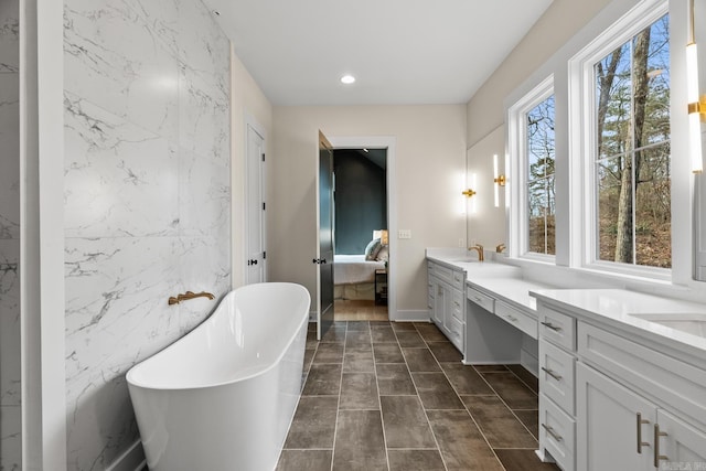 bathroom with tile walls, a washtub, and vanity