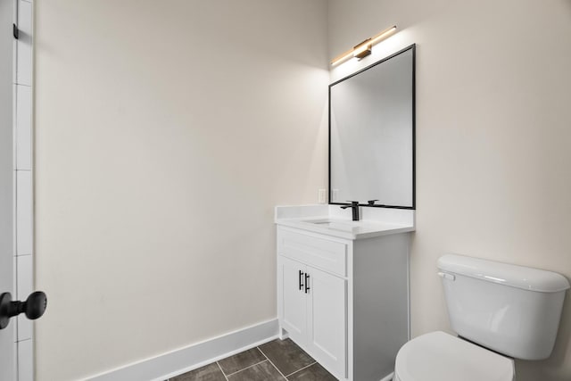 bathroom with toilet, vanity, and tile patterned flooring