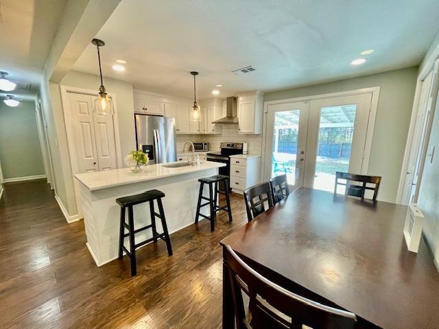 dining area featuring dark hardwood / wood-style floors, french doors, and sink