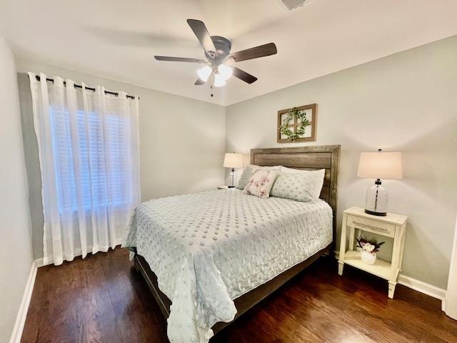 bedroom with ceiling fan and dark wood-type flooring