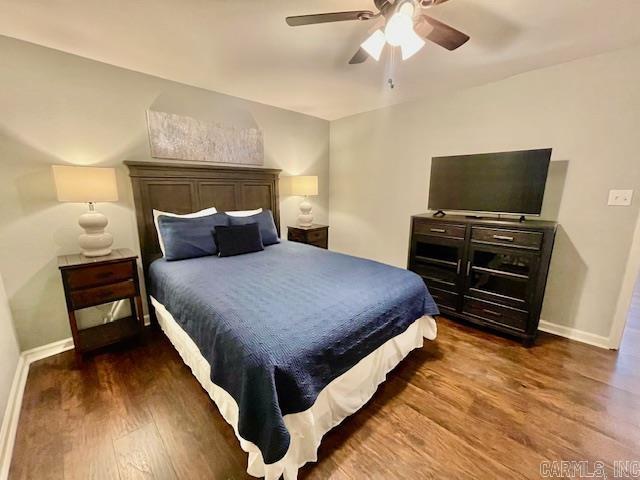 bedroom with ceiling fan and dark wood-type flooring