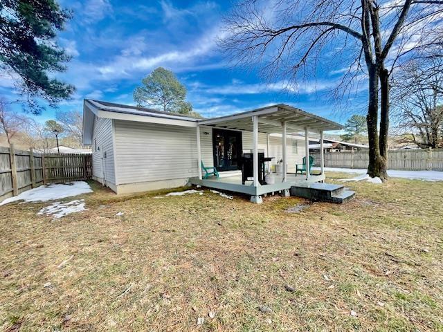 back of property with a lawn and a wooden deck