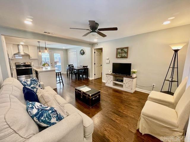 living room featuring ceiling fan, sink, and dark hardwood / wood-style flooring