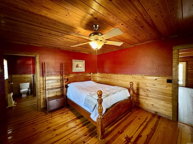 bedroom featuring ceiling fan, wood ceiling, hardwood / wood-style floors, and ensuite bath