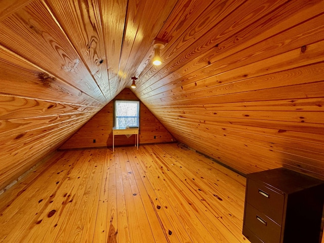 additional living space featuring light hardwood / wood-style floors, wooden ceiling, vaulted ceiling, and wooden walls