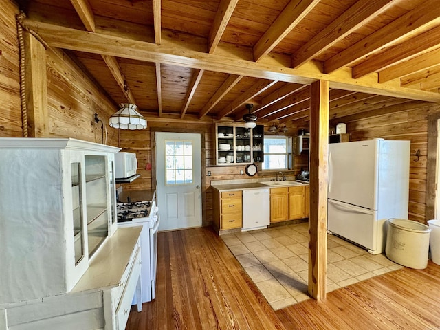 kitchen featuring wood walls, sink, white appliances, and light hardwood / wood-style floors