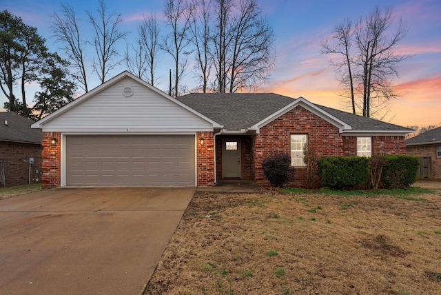 ranch-style house with a garage and a lawn